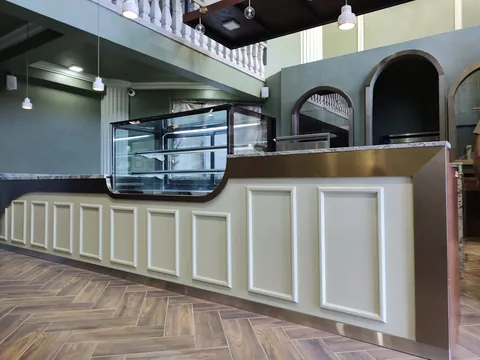 Barra de cafetería con molduras y vitrina refrigerada