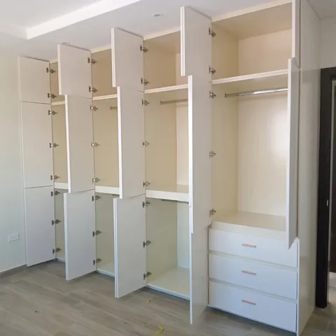 Interior de clóset con tubos, entrepaños y cajonera