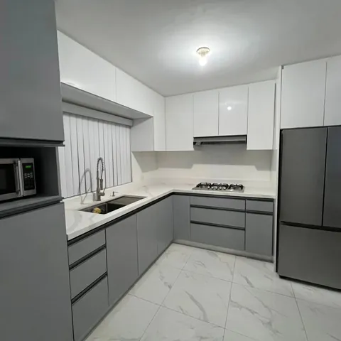 Cocina en L gris oxford mate y blanco brillante, sin jaladeras con perfil gola