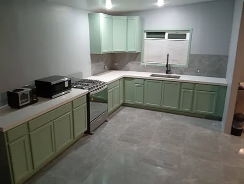 Cocina en L verde con puertas tipo shaker