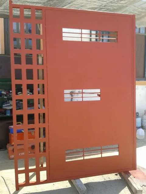Puerta de herrería de diseño con cuadrícula lateral