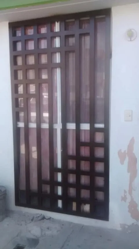 Puerta de herrería con reja cuadriculada