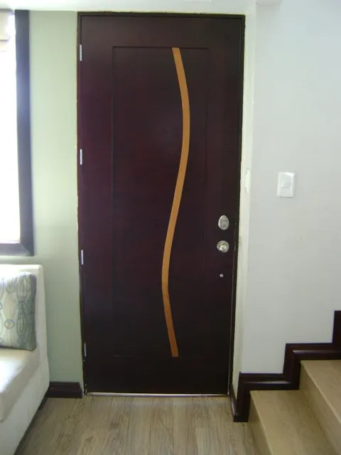 Puerta principal de madera con incrustación