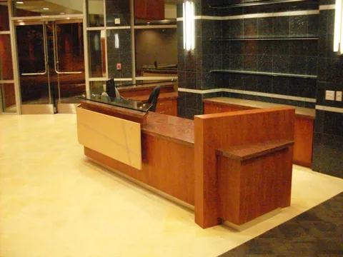 Recepción corporativa en madera con cubierta de granito