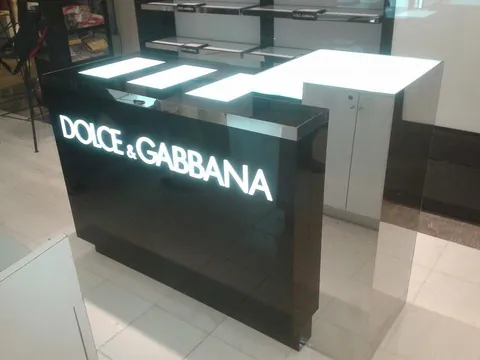 Mostrador de perfumería en negro alto brillo con logotipo iluminado